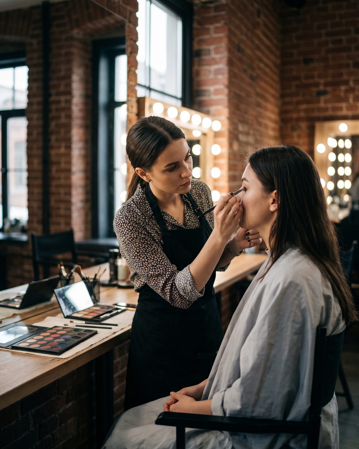 Make-up artistkinja radi šminku na klijentkinji u studiju